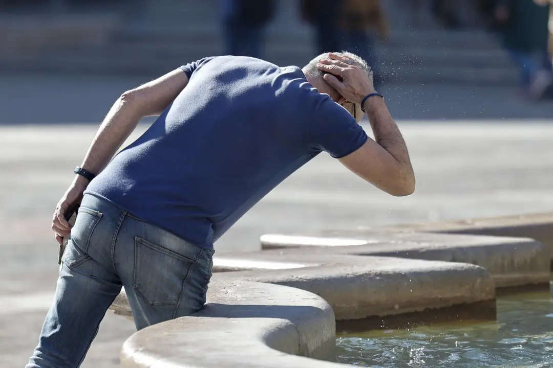 Un hombre se refresca en una fuente en Valencia. - EFE