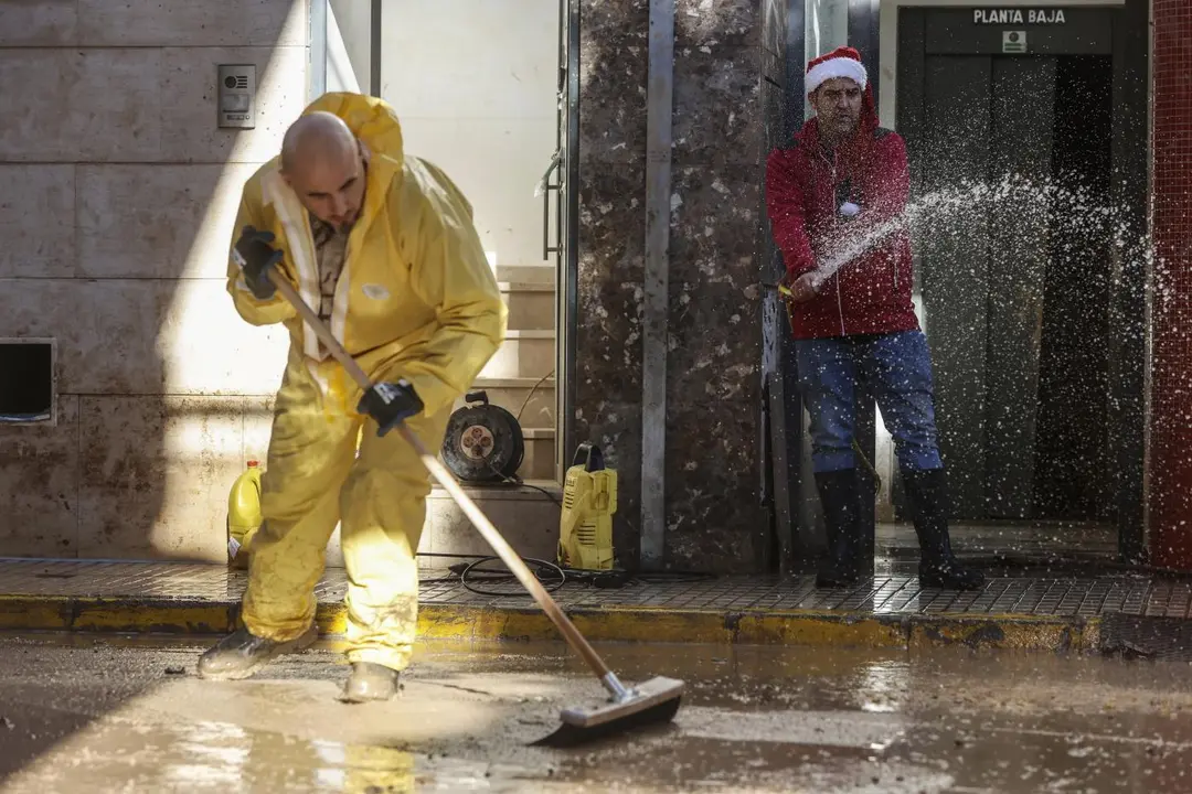 Un hombre con un gorro de Pap&aacute; Noel ayuda a limpiar. - Europa Press