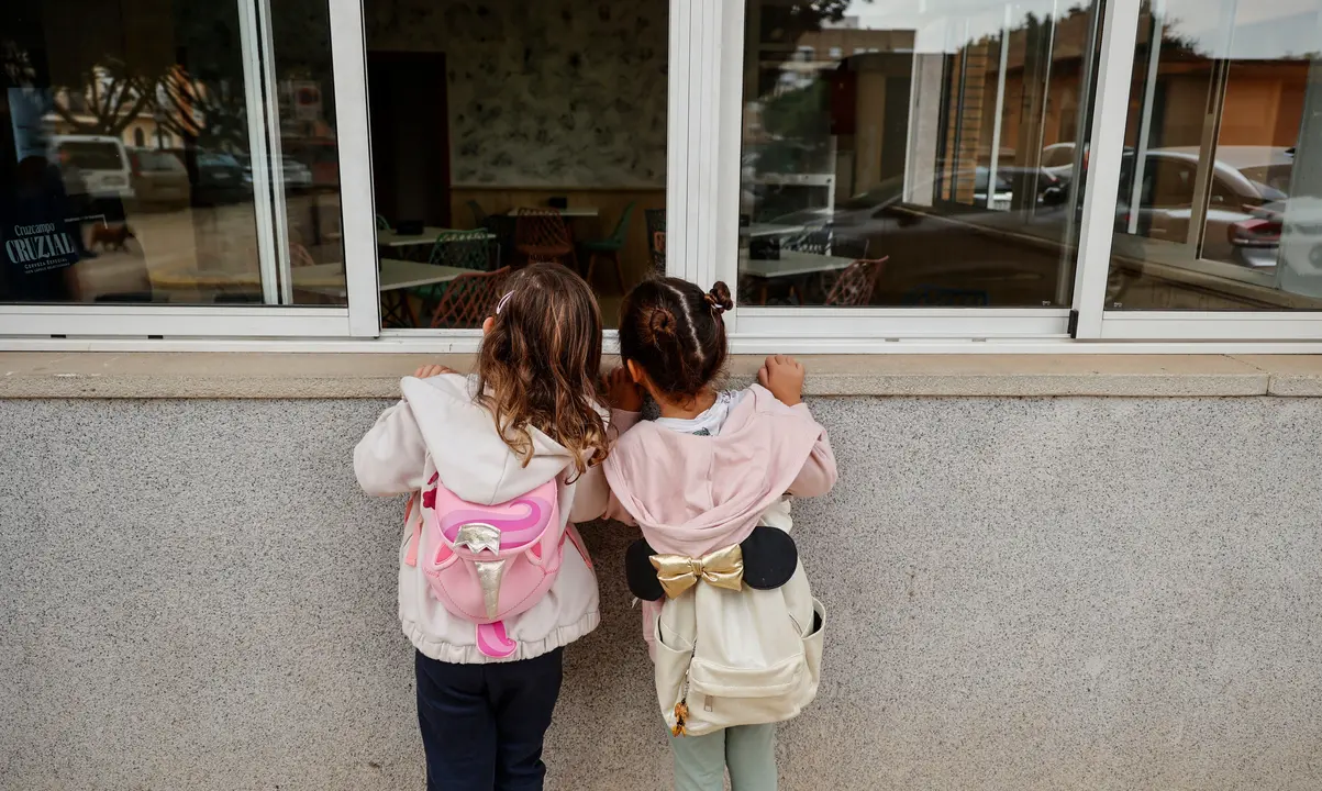 Dos ni&ntilde;as observan el interior de un colegio. | EP