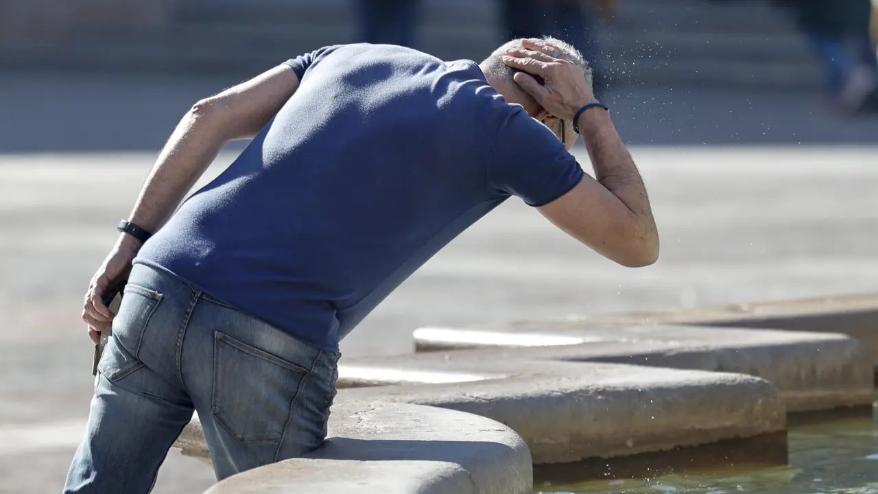 Un hombre se refresca en una fuente en Valencia. - EFE