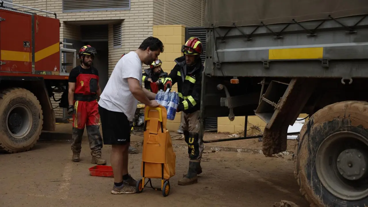 Efectivos de la UME reparten agua a los vecinos de Paiporta. - EFE/ Biel Ali&ntilde;o