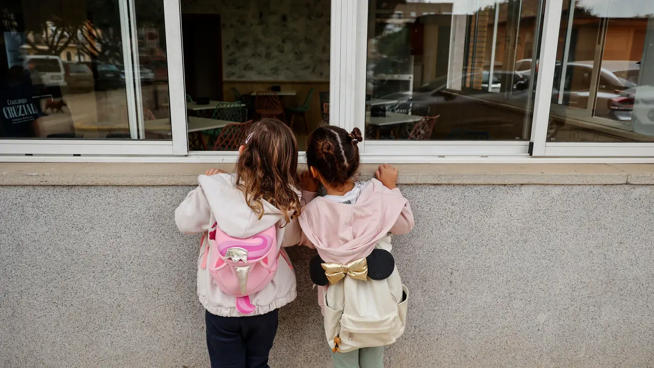 Dos ni&ntilde;as observan el interior de un colegio. | EP